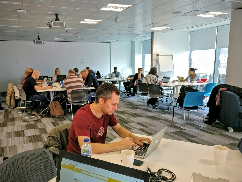 Photo of people say at tables for contributor Day, WordCamp Manchester 2016